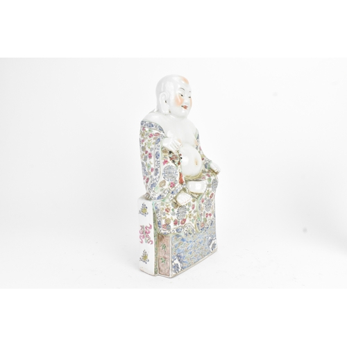 14 - A Chinese famille rose porcelain model of a Buddha, seated holding a beaded necklace, his robe decor... 