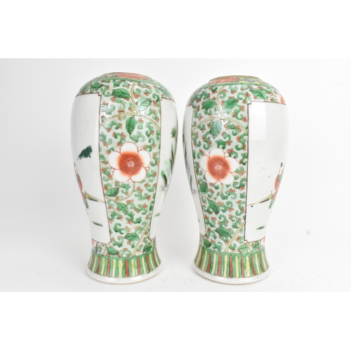 20 - A pair of 19th century Chinese famille vert vases in Kangxi style, of baluster form with elaborate p... 