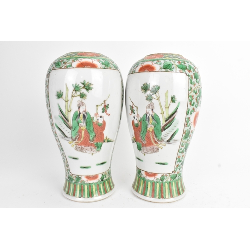 20 - A pair of 19th century Chinese famille vert vases in Kangxi style, of baluster form with elaborate p... 