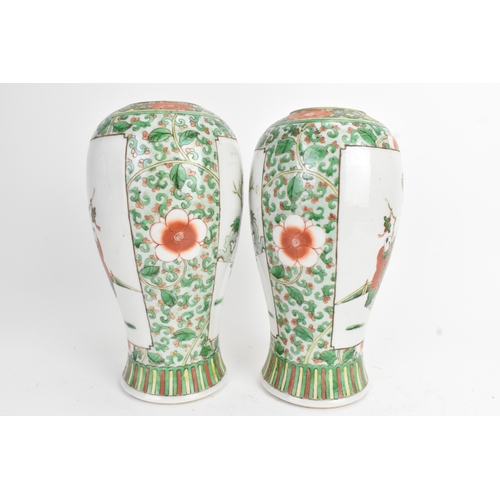 20 - A pair of 19th century Chinese famille vert vases in Kangxi style, of baluster form with elaborate p... 