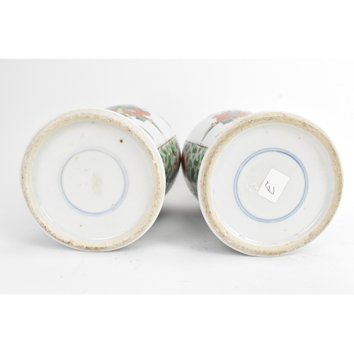 20 - A pair of 19th century Chinese famille vert vases in Kangxi style, of baluster form with elaborate p... 