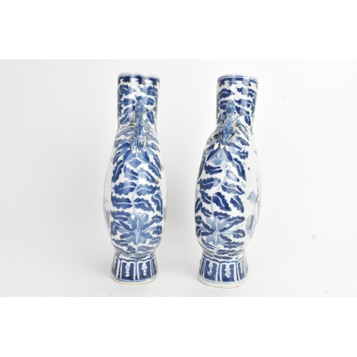21 - A pair of Chinese blue and white porcelain moon flasks, late Qing dynasty, of flattened circular for... 