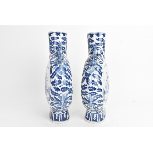 21 - A pair of Chinese blue and white porcelain moon flasks, late Qing dynasty, of flattened circular for... 