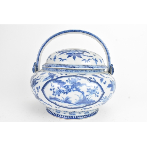 23 - A Japanese blue and white porcelain covered basket-form vessel, of globular form with domed pierced ... 