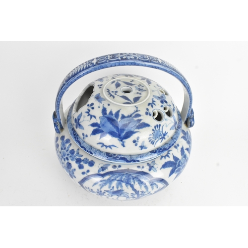 23 - A Japanese blue and white porcelain covered basket-form vessel, of globular form with domed pierced ... 