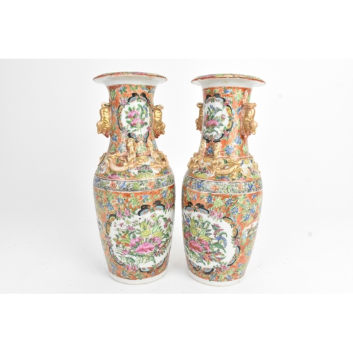 24 - A pair of Chinese export famille rose porcelain vases, late Qing dynasty, each with applied lion dog... 