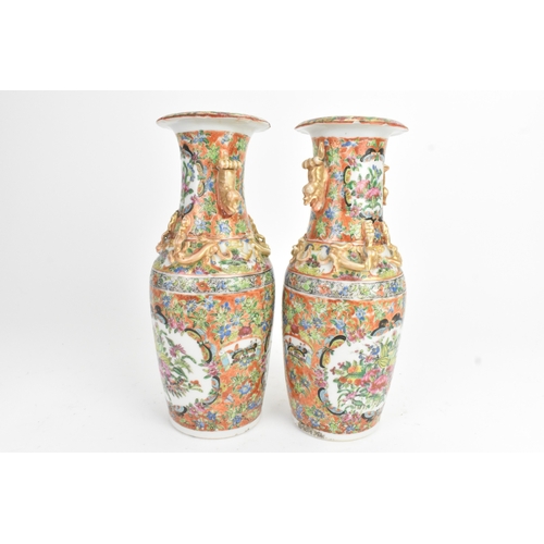 24 - A pair of Chinese export famille rose porcelain vases, late Qing dynasty, each with applied lion dog... 