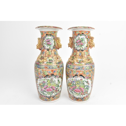 24 - A pair of Chinese export famille rose porcelain vases, late Qing dynasty, each with applied lion dog... 