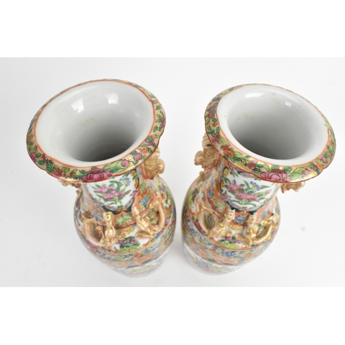 24 - A pair of Chinese export famille rose porcelain vases, late Qing dynasty, each with applied lion dog... 