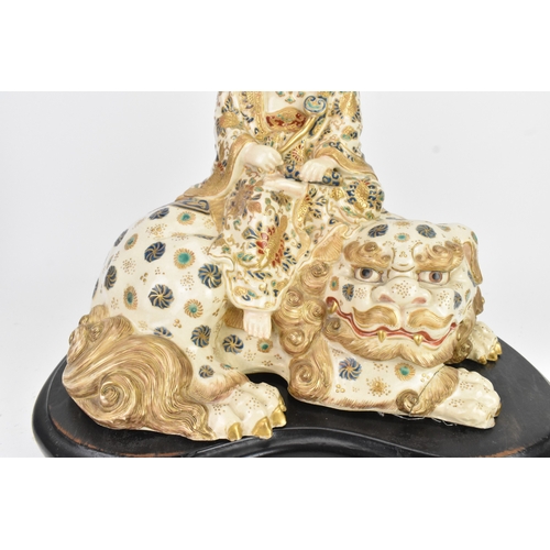 32 - A Japanese Satsuma figure group, early 20th century, modelled as Guanyin seated on a shi-shi lion, d... 