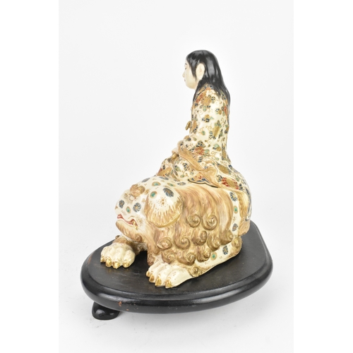 32 - A Japanese Satsuma figure group, early 20th century, modelled as Guanyin seated on a shi-shi lion, d... 