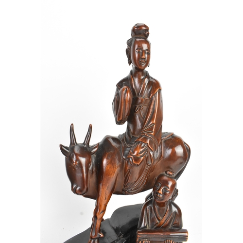 37 - Two Chinese hardwood carved figures, 20th century, one modelled seated upon a shi-shi lion and holdi... 