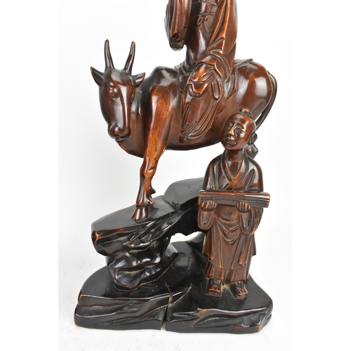 37 - Two Chinese hardwood carved figures, 20th century, one modelled seated upon a shi-shi lion and holdi... 