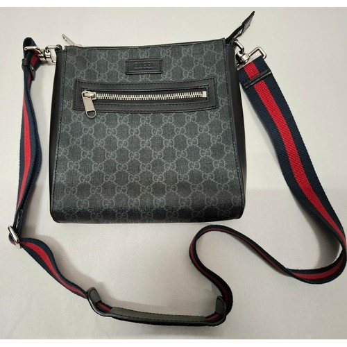 7 - Gucci- A circa 2020 GG supreme canvas messenger bag in grey having silver tone hardware and a navy a... 