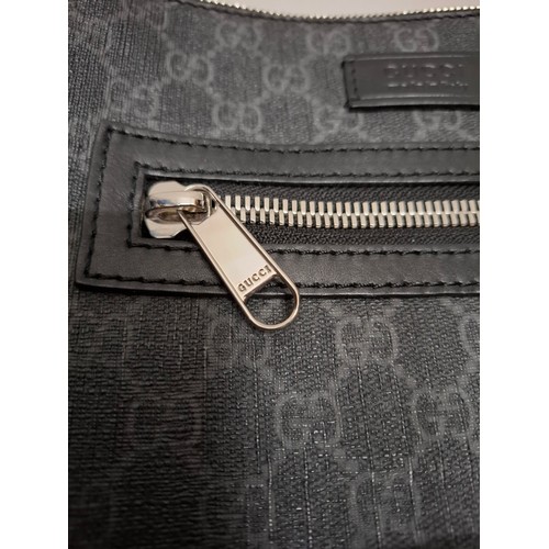 7 - Gucci- A circa 2020 GG supreme canvas messenger bag in grey having silver tone hardware and a navy a... 