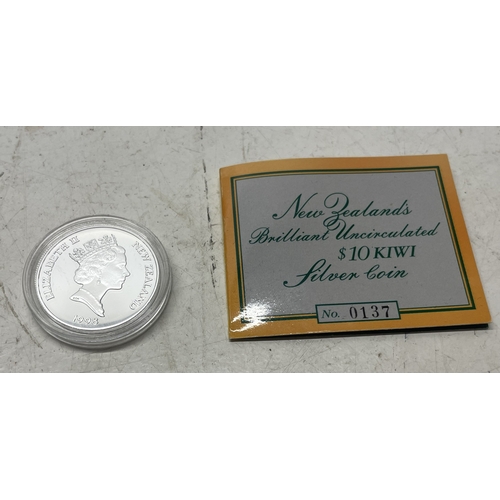 20 - A collection of five New Zealand $1 silver coins in presentation packs and a 1998 New Zealand $10 wi... 