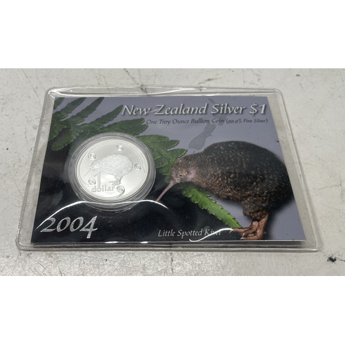 20 - A collection of five New Zealand $1 silver coins in presentation packs and a 1998 New Zealand $10 wi... 