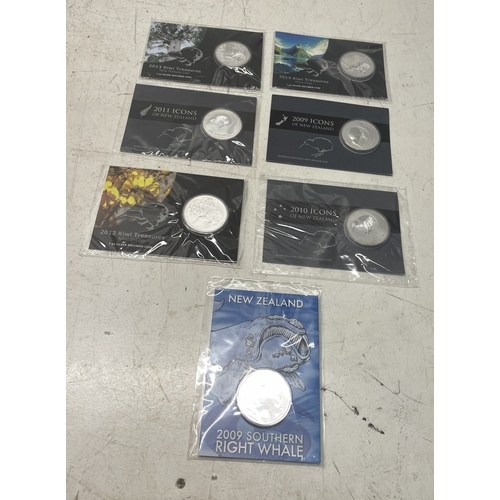 33 - A collection of seven New Zealand $1 silver coins in presentation packs, combined weight of coins 20... 