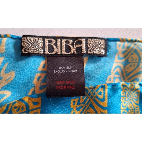 18 - Biba- A silk turquoise wrap having a black, silver and gold Biba design with hand-rolled edges toget... 