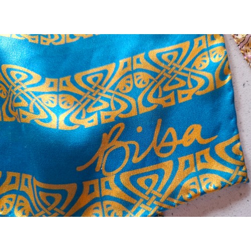 18 - Biba- A silk turquoise wrap having a black, silver and gold Biba design with hand-rolled edges toget... 