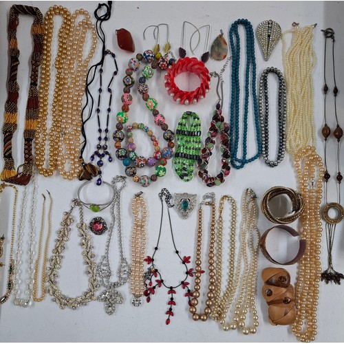55 - A quantity of costume jewellery to include painted beads, a tiger's eye pendant, simulated pearls an... 
