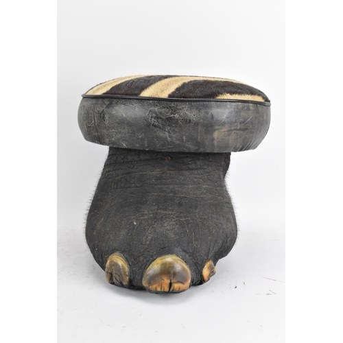 246 - Taxidermy: A late 19th/early 20th century Elephants foot fashioned into a stool, having a zebra skin... 