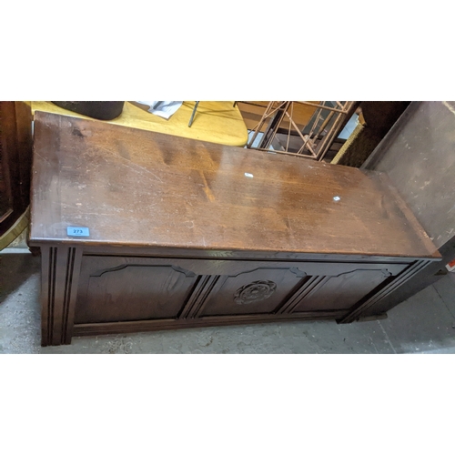 273 - A carved oak blanket chest with tri-fielded front having carved flower head decoration, hinged top, ... 