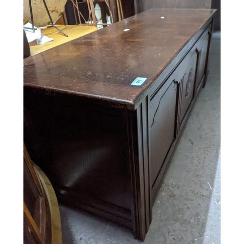 273 - A carved oak blanket chest with tri-fielded front having carved flower head decoration, hinged top, ... 