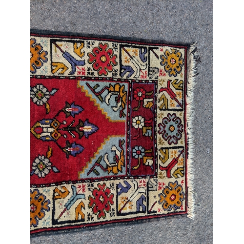 198 - A handwoven Turkish runner with cream blue and orange central medallions with a cream stylized borde... 