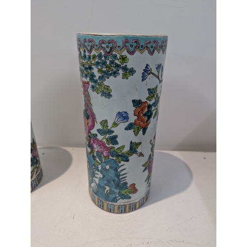38 - A pair of 20th century Chinese famille rose porcelain cylinder vases decorated with peacocks with re... 