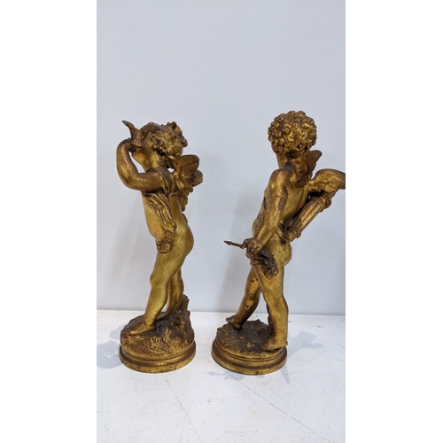 311 - After Auguste Moreau - a pair of gilt spelter cherubs on naturalistic bases, one holding birds, 28cm... 