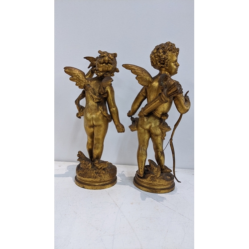 311 - After Auguste Moreau - a pair of gilt spelter cherubs on naturalistic bases, one holding birds, 28cm... 