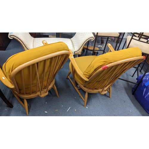 319 - A pair of Ercol light beech spindle back armchairs, having loose cushions and on tapering legs
Locat... 