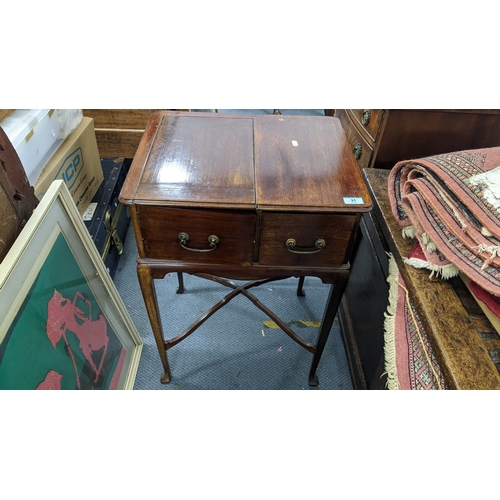 31 - A mid-20th century mahogany smoker's table, the top having a sliding fitted compartment and the cabr... 