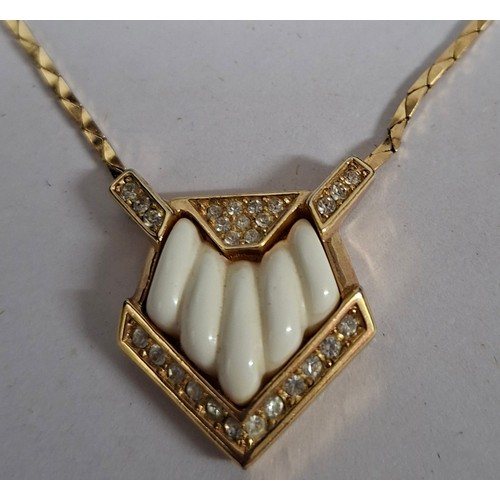2 - Christian Dior- A 1980's gold tone necklace having a pentagon pendant with inset white rhinestones s... 