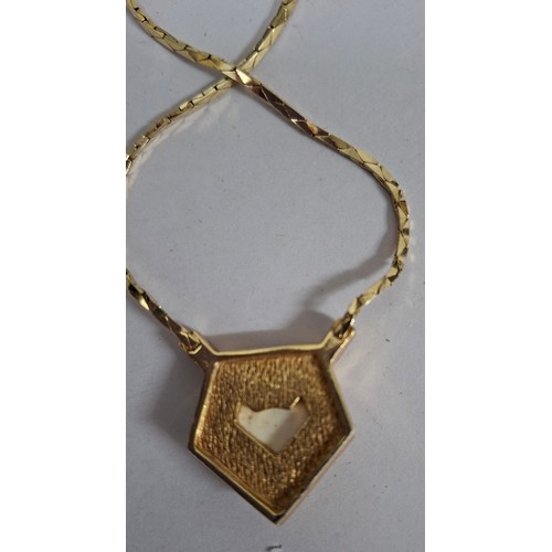 2 - Christian Dior- A 1980's gold tone necklace having a pentagon pendant with inset white rhinestones s... 