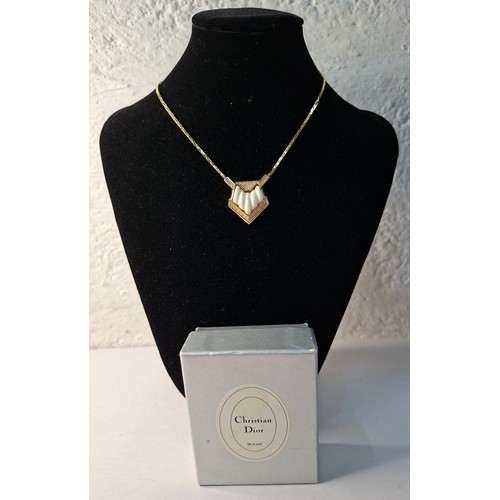 2 - Christian Dior- A 1980's gold tone necklace having a pentagon pendant with inset white rhinestones s... 