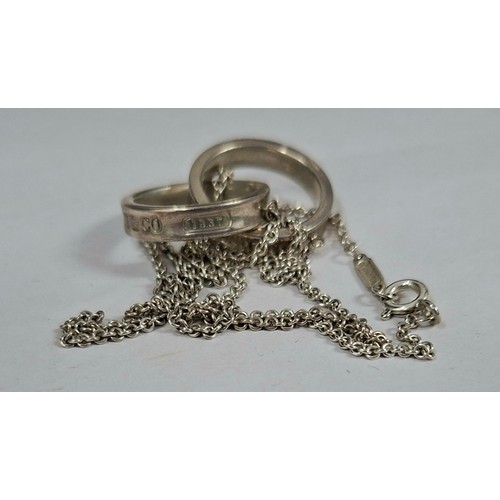 38 - Tiffany & Co- A silver necklace having an interlocking double ring pendant stamped 925 Tiffany & Co,... 
