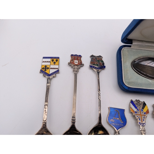 22 - A collection of silver and enamel souvenir spoons, decorated with enamel crest to the terminals to i... 