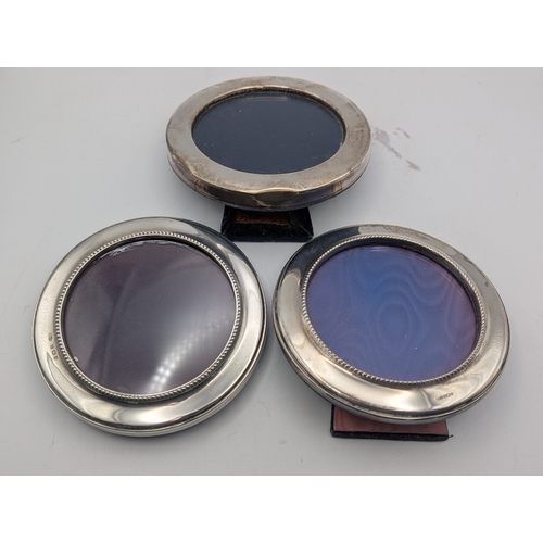 24 - Three silver fronted photograph frames to include a pair having beaded decoration, all in circular f... 