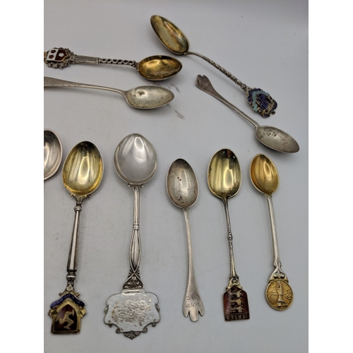 51 - A collection of silver souvenir spoons to include golfing examples and other spoons labelled Scarbor... 