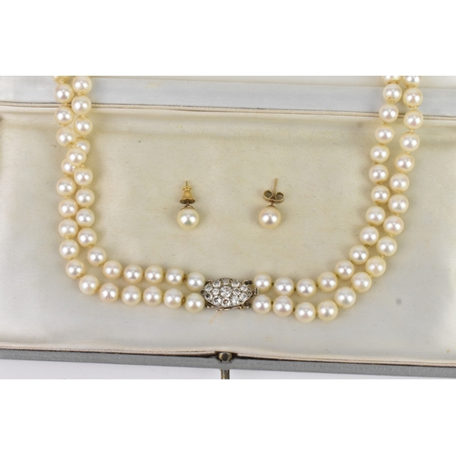 13 - A double strand pearl necklace, having a yellow and white metal diamond cluster set marquise shape b... 