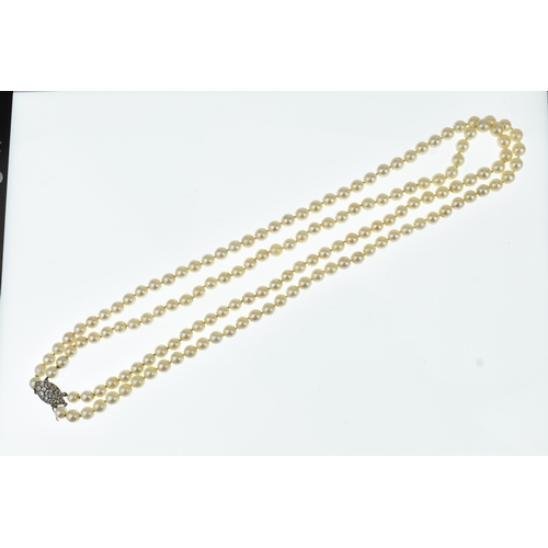 13 - A double strand pearl necklace, having a yellow and white metal diamond cluster set marquise shape b... 