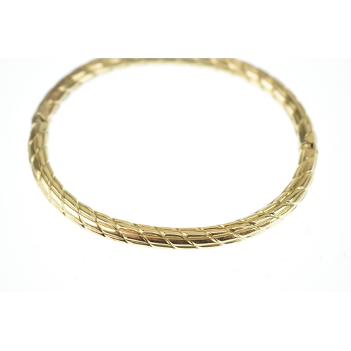 18 - A 9ct yellow gold hinged bangle, with diamond cut pattern, box clasp stamped 375, 7cm x 6cm, 13.7g
L... 