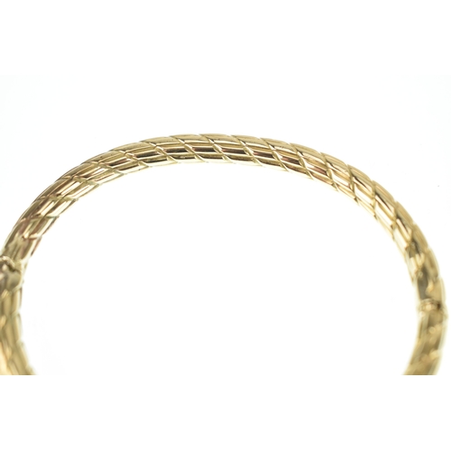 18 - A 9ct yellow gold hinged bangle, with diamond cut pattern, box clasp stamped 375, 7cm x 6cm, 13.7g
L... 