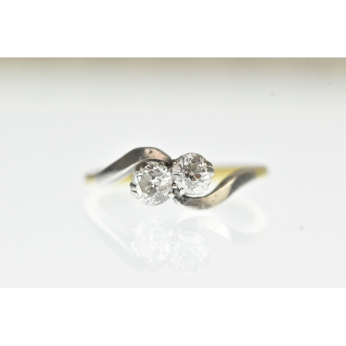 34 - A two stone diamond 18ct yellow gold and platinum crossover ring, with two brilliant cut claw set di... 