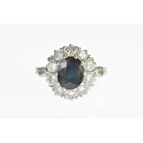 35 - A sapphire and diamond 18ct white cluster ring, with a central oval cut claw set sapphire, surrounde... 