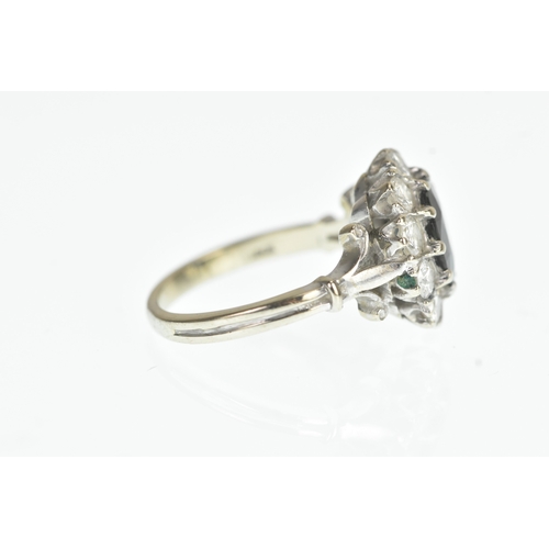 35 - A sapphire and diamond 18ct white cluster ring, with a central oval cut claw set sapphire, surrounde... 