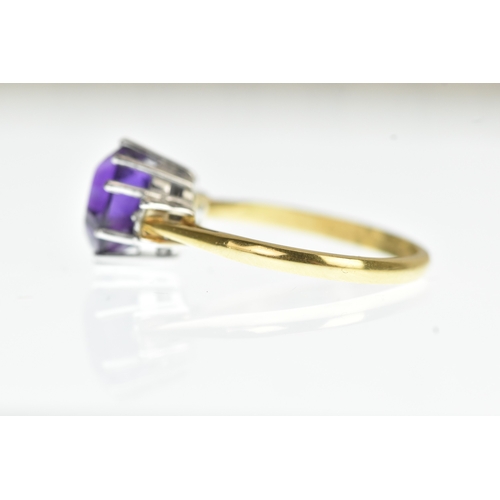 36 - A purple amethyst and diamond 18ct yellow and white gold dress ring, with central oval cut claw set ... 