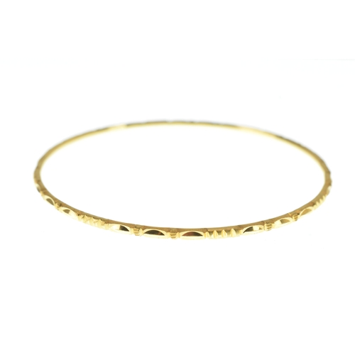 40 - A 22ct yellow gold bangle, of circular form and decorated with alternating faceted oval panels and e... 